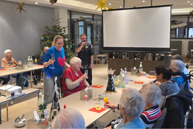 Malsch: Feiernde beim Neujahrsempfang vor Leinwand.
