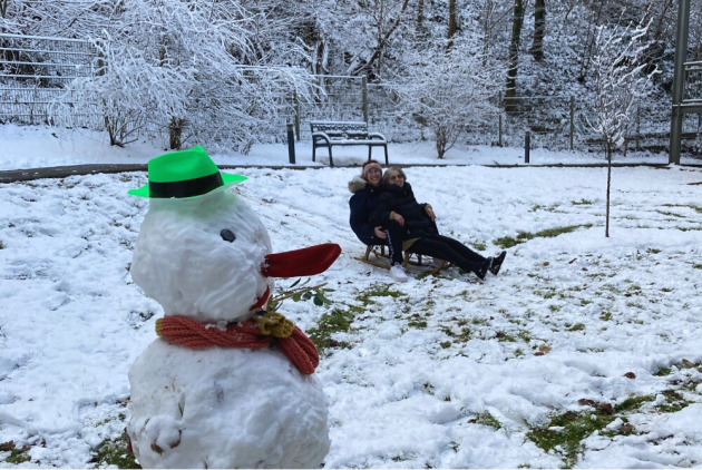 Bensheim: Mitarbeiterin und Bewohnerin auf Schlitten hinter Schneemann.