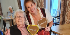 Bensheim: Bewohnerin und Mitarbeiterin in Dirndl mit gebastelten Herzen.