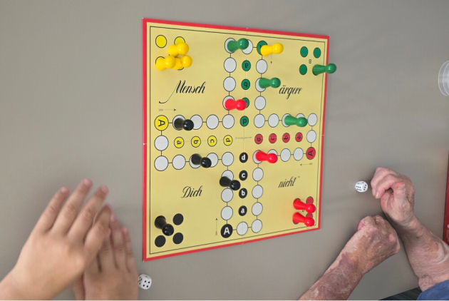 Malsch: Kind und SeniorIn spielen das Brettspiel "Mensch ärgere dich nicht".