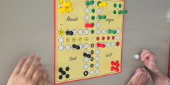 Malsch: Kind und SeniorIn spielen das Brettspiel "Mensch ärgere dich nicht".