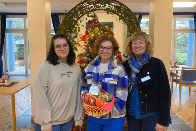 Dudenhofen: Mitarbeitende mit Geschenkkorb voller Leckereien.