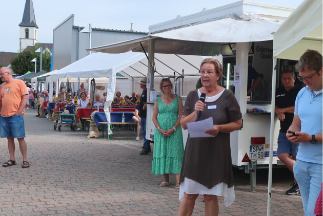 Dudenhofen: Einrichtungsleiterin eröffnet Bauernmarkt vor Ständen.