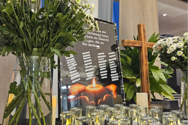 Malsch: Gedenktisch mit Blumen, Kreuz, Lichtern und Namen Verstorbener in einem Bilderrahmen.