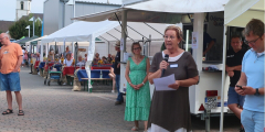 Dudenhofen: Einrichtungsleiterin eröffnet Bauernmarkt vor Ständen.