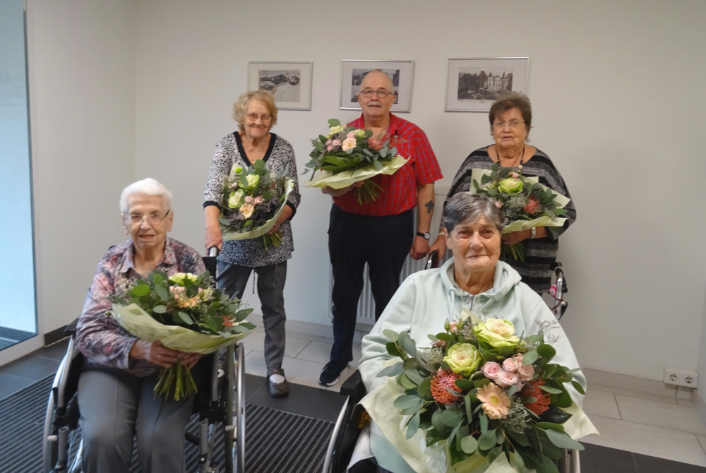 Lindenfels: Neuer 5-köpfiger Einrichtungsbeirat mit Blumensträußen.